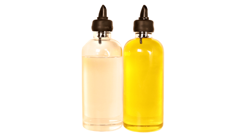2 glass bottles, each 500ml, containing oil, with spouts for pouring. Use for pantry or display in kitchen